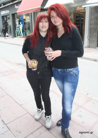 Δύο κοκκινομάλλες κοιτάζουν τις βιτρίνες με τον καφέ στο χέρι